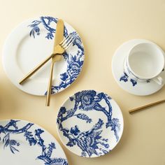 blue and white plates with gold cutlery on the top, next to each other