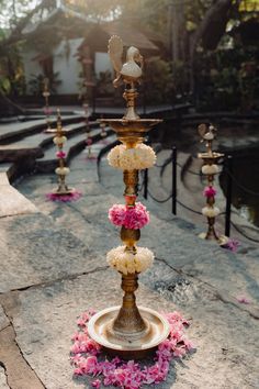 an elaborately decorated fountain with flowers on the ground