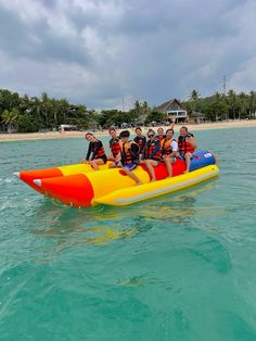 a group of people riding on the back of an inflatable raft through clear blue water