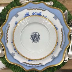 an ornate blue and gold plate with two elephants on the center, surrounded by silverware