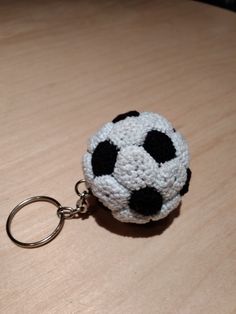 a crocheted keychain with a soccer ball on it sitting on a table