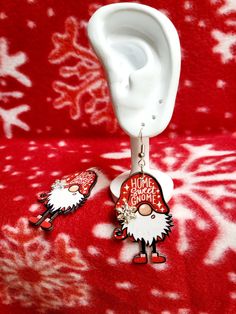 Welcome to my shop! You are looking at a pair of adorable Christmas Gnome dangle earings. These thin wooden earrings are about 3 inches with a pretty little jeweled snow flake on his hat. Picture is on one side and the back side is blank. Perfect edition to your holiday outfits! Spend at least 35 and get free shipping! Thanks for stopping by while you're here check out my other items! Everything is handmade by me with peace love and glitter! Snow Flake, Wooden Earrings, Christmas Gnome, Peace Love, Holiday Outfits, Christmas Home, Peace And Love, Jewelry Earrings Dangle, Sweet Home