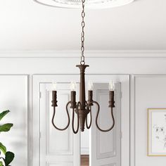 a chandelier hanging from the ceiling in a room with white walls and doors