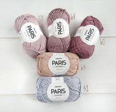 four balls of yarn sitting next to each other on top of a white surface with the words paris written across them