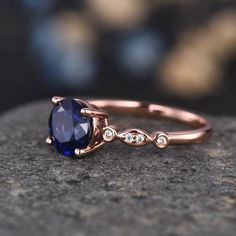 a close up of a ring with a blue stone on the top and diamonds around it