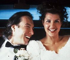 a bride and groom sitting in the back of a car