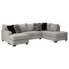 a sectional couch with pillows on the back and side facings, sitting in front of a white background