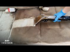 a person using a vacuum to clean a car's seat with the help of a blue glove