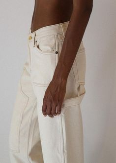 Still Here NYC subway jeans in bone off white, a modern take on traditional carpenter pants. Mid-rise, wide leg, wedgie fit jean with an exaggerated front waistband pitch and front patch panelling. Button Fly and signature SH embroidery. We suggest taking your trie to size as it has a naturally oversized fit. Cassie is 5'9" and wears a size 26. 80% upcycled cotton, 20% organic cotton. SB-BN-PA PIPE AND ROW White Utility Jeans With Belt Loops, Cream Wide Leg Denim Pants, Cream Wide-leg Denim Pants, White Wide Leg Rigid Denim Bottoms, White Wide-leg Rigid Denim Bottoms, Chic Rigid Denim Pants With Pockets, Chic Cream Jeans With Pockets, New York Subway, Nyc Subway