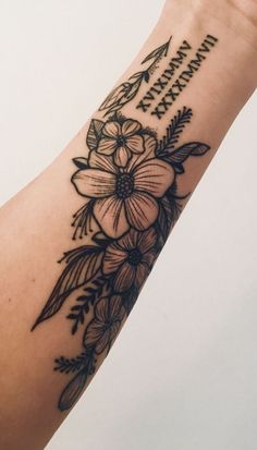 a woman's arm with flowers and an arrow on it that says happy birthday