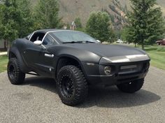 a black car parked on top of a gravel road