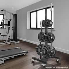 an empty gym with dumbs and treadmills on the floor in front of large windows