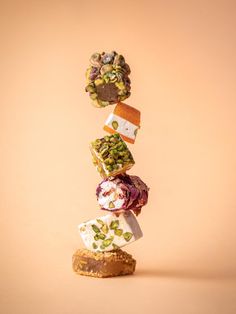 a stack of different types of food on top of each other in front of a beige background