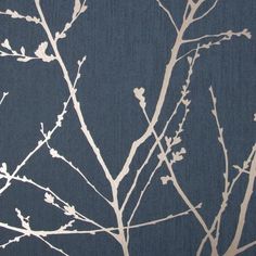 the branches of a tree against a blue wallpaper with white and gray leaves on it