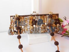 "A vintage beaded evening bag with lots of sparkle and glam. It has a background of brown taffeta. This is covered with beads and sequins in gold, silver, copper and grey. The bag interior is brown taffeta with one pocket. The bag has a silvertone frame and a kiss lock. This glam beaded clutch bag also includes a bead handle. This sparkly bead bag is a beautiful after five bag. MATERIAL: Beads, taffeta CONDITION: Good SIZE: 11\" wide, 4\" high COLOR: Silver, gold, copper, brown" Brown Embellished Evening Bag, Handmade Brown Evening Bag For Party, Beaded Brown Evening Bag For Party, Embellished Brown Evening Bag For Party, Vintage Brown Clutch For Party, Handmade Brown Clutch For Party, Holiday Handbag, Copper And Grey, Purple Clutch