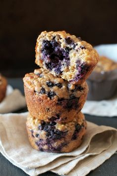 blueberry muffins stacked on top of each other with one bite taken out