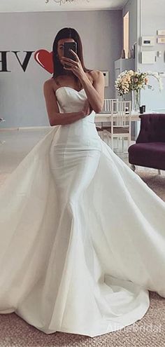 a woman is taking a selfie in her wedding dress