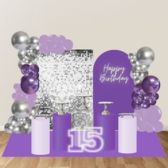 a purple and silver birthday party set up on a wooden floor with balloons in the background