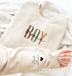 Stay cozy and stylish with our Personalized Boy Mom Sweatshirt featuring your little one's name on the sleeve. This Momma Sweatshirt is the perfect gift for any mom, whether she's an expecting mom or a seasoned Boy Mama. Show your love for your little guy with this unique and thoughtful piece, making it one of the best Presents for Mom. Dress it up or down, this sweatshirt is a must-have for any proud Boy Mom! PRODUCT DETAILS 💡 ✅ Material: 50% cotton and 50% polyester  ✅ Medium-heavy fabric: (8 Best Presents For Mom, Momma Sweatshirt, Boy Mom Sweatshirt, Good Presents For Mom, Boy Mom Shirt, Mom Of Boys Shirt, Boy Mama, Expecting Mom Gifts, Moms Club