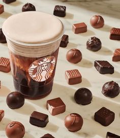 a cup of starbucks coffee surrounded by chocolates