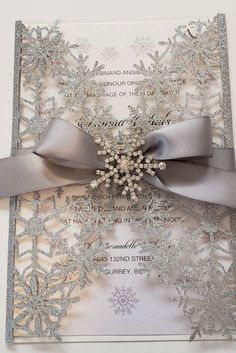 a wedding card with silver ribbon and snowflakes