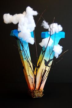 a vase with some branches and clouds in it