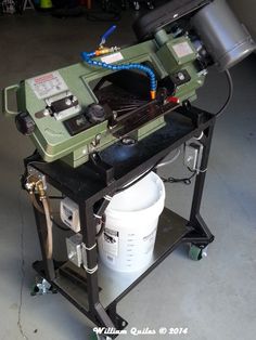 a machine that is sitting on top of a table with a bucket in front of it