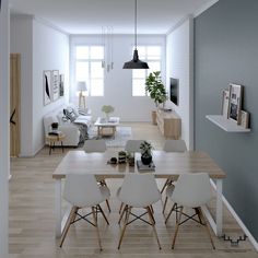 a living room and dining area in an apartment with wood flooring, white walls and furniture