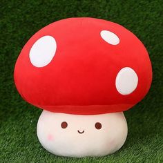 a red mushroom sitting on top of a lush green field