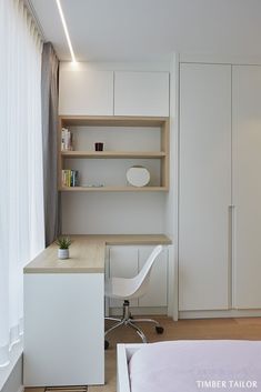 a bedroom with a bed, desk and bookcases in white wood paneling