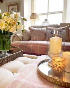 a living room filled with lots of furniture and flowers on top of a coffee table