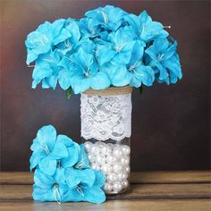 blue flowers and pearls are in a vase