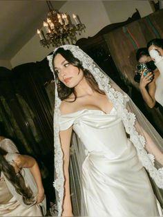 a woman in a white wedding dress and veil