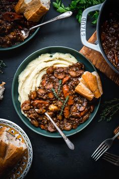 a plate with mashed potatoes, meat and gravy next to other dishes