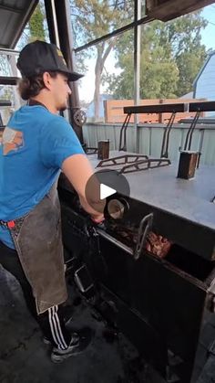 a man standing next to an outdoor grill