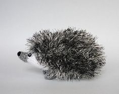 a small hedgehog toy sitting on top of a white floor next to a wall