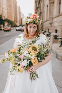 a woman in a white dress holding a bouquet of flowers