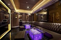 a fancy restaurant with purple lighting and leather booths