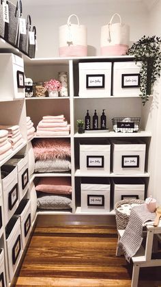 an organized closet with white drawers and pink towels on the shelves, along with black and white bins