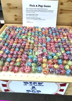 a display case filled with lots of different colored candies on top of a wooden table