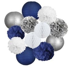 blue and white paper flowers are arranged in a circle on the wall with silver balls