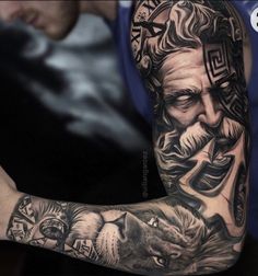 a man with tattoos on his arm holding a cell phone