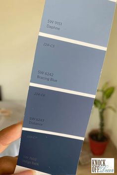 someone holding up some blue paint swatches in their hand and the colors are different