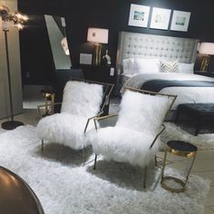 two white chairs sitting next to each other on top of a rug in a bedroom