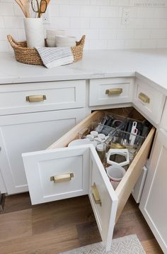 an open drawer in a white kitchen