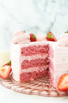 a strawberry layer cake with white frosting and fresh strawberries on the top slice