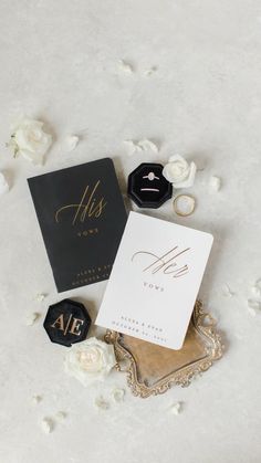 wedding stationery and rings laid out on a bed of white roses with the bride's ring