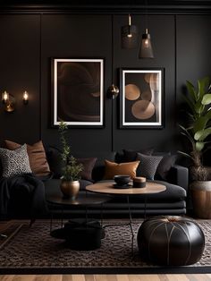 a living room with black walls and wooden flooring, two pictures on the wall