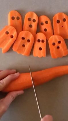 someone is cutting up carrots with holes in them