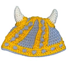 a crocheted hat with horns is shown in yellow and gray colors on a white background